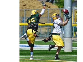 Eskimos #25 Mike Miller makes a catch on defender #45 Dexter McCoil during practice at Fuhr Sports Park in Spruce Grove on June 24, 2015.