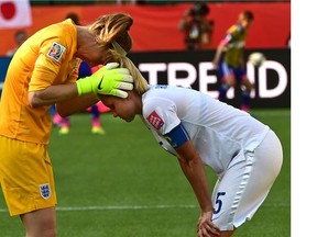 England goalkeeper Karen Bardsley (1) comforts Steph Houghton (5) after losing to Japan 2 - 1 during the semi-final match at the 2015 FIFA Women's World Cup at Commonwealth Stadium in Edmonton, July 2, 2015.