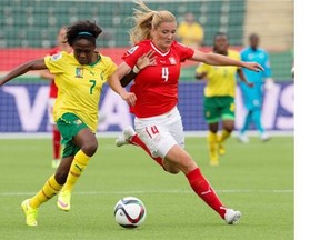 Switzerland’s Rachel Rinast (4) and Cameroon’s Gabrielle Onguene (7) battle for the ball during the first half of FIFA World Cup action in Edmonton on Tuesday June 16, 2015.