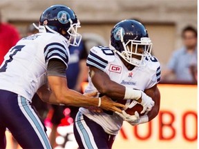 Toronto Argonauts quarterback Trevor Harris hands the ball to running back Henry Josey during a Canadian Football League pre-season game against the Montreal Alouettes at Montreal on June 18, 2015.
