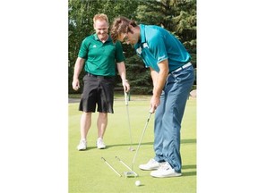 University of Alberta golf coach Robin Stewart helps Connor Grimes with his putting stroke during a practice session on June 23, 2015.