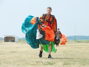 Wingsuit jumpers land with a parachute as they practice for the 2015 Alberta Wingsuit Performance Competition at Eden North Parachute School west of Edmonton on July 10, 2015.