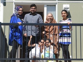 The Ahmed family — Rashid, Summiya and their daughters Ameerah, 10; Amaana, 6; and Ayra, 5; and mother-in-law, Naseem (visiting from Pakistan) — check out their new digs as six families received keys to their new home in the largest Habitat build in Canada at Neufeld Landing in Edmonton on Thursday, July 30, 2015.