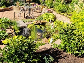 Pat and Jon Brehaut’s backyard contains a reflecting pond, surrounded by Rundle rock and lush aquatic plants.