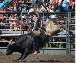 Bull riding during the opening rodeo event at Big Valley Jamboree in Camrose on July 30, 2015