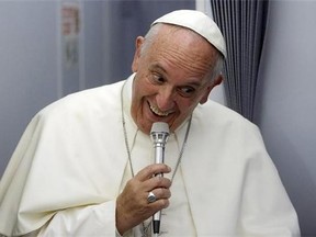 In this photo taken on Sunday, July 12, 2015, Pope Francis smiles as he meets the media during an airborne press conference aboard the airplane directed to Rome, at the end of his Apostolic journey in Ecuador, Bolivia and Paraguay.