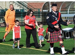 Claire Woodall and her sons take part during the opening ceremony for the Woodall Cup at Clarke Park in Edmonton on Sunday July 26, 2015.