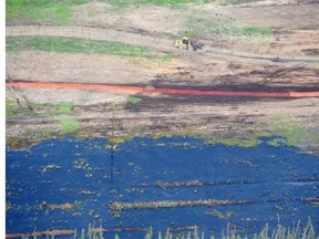 Crews work to clean the spill of bitumen, water and sand near Nexen’s Long Lake facility near Fort McMurray on Friday July 17, 2015. The spill is enough to fill two Olympic-sized swimming pools.