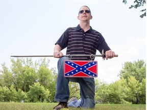 Dale Pippin, whose family is originally from North Carolina, poses with a replica Civil War sabre and Confederate flag licence plate on July 18, 2015 in Saskatoon.