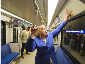 Dorian Wandzura, transportation services manager, looks on as City Coun. Bev Esslinger demonstrates pushing the emergency call button and talking to security on the train during the unveiling of the ETS zero-tolerance for sexual harassment campaign in Edmonton on Tuesday August 18, 2105.