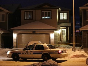A police car sits outside a home in Edmonton Dec. 30, 2014, where seven dead bodies were discovered.