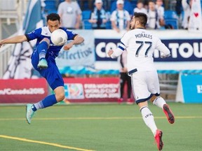 FC Edmonton’s Cristian Raudales tries to control the ball in front of Vancouver Whitecaps’ Pedro Morales during an Amway Canadian Championship semifinal match at Clarke Field on May 20, 2015.