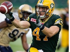 Edmonton Eskimo middle linebacker J.C. Sherritt tosses the ball to teammate Dexter McCoil after making an interception against the Winnipeg Blue Bombers during Saturday’s Canadian Football League game at Commonwealth Stadium.