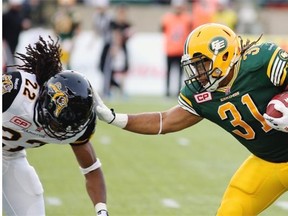 Edmonton Eskimos Calvin McCarty (right) eludes a tackle from Hamilton Tiger Cats Courtney Stephen (left) during Canadian Football League game action in Edmonton on August 21, 2015.