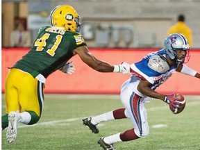 Edmonton Eskimos defensive end Odell Willis grabs the jersey of Montreal Alouettes quarterback Rakeem Cato to make one of his three quarterback sacks in a Canadian Football League game on Aug. 13, 2015, in Montreal.