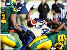 Edmonton Eskimos defensive tackle Almondo Sewell causes a fumble when he wrestles Winnipeg Blue Bombers running back Paris Cotton to the ground in a Canadian Football League game at Commonwealth Stadium on Oct. 13, 2014.