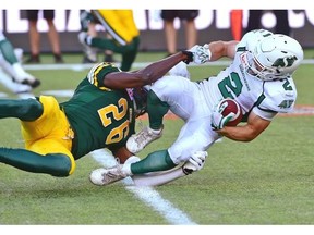 Edmonton Eskimos John Ojo takes down Saskatchewan Roughriders Ryan Smith after a reception during CFL action at Commonwealth Stadium on Friday.