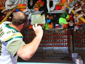 Edmonton Eskimos offensive lineman Brian Ramsay tries out the milk jug carnival game at Capital Ex at Northlands on July 25, 2011.