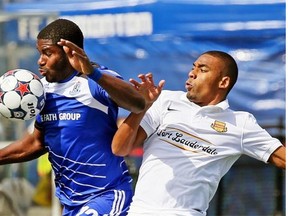 FC Edmonton midfielder Kareem Moses, left, and Fort Lauderdale Strikers forward Stefano Pinho battle for the ball during Sunday’s North American Soccer League game at Clarke Field.