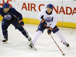 Edmonton Oiler Connor McDavid (right) eludes defenceman Loik Leveille (left) during a four-on-four intrasquad game at Rexall Place in Edmonton on July 6, 2015, after the team’s six day orientation camp. This is the first game that Connor McDavid has played as an Edmonton Oiler.