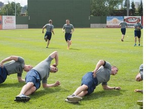 Edmonton Police Service recruits take part in a physical training exercise with some of the Edmonton Prospects baseball player at Telus Field, in Edmonton on July 16, 2015.