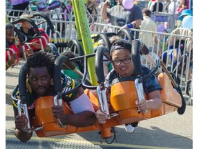 Eskimos defensive end Marcus Howard rides with a fan during Monday Morning Magic at K-Days.