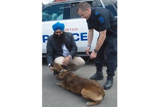Federal Multiculturalism Minister Tim Uppal joins Edmonton police officer Const. Jason Born, with police service dog Xeiko, on Thursday to mark the enactment of the Justice for Animals in Service Act, or Quanto’s Law, inspired by an Edmonton police dog fatally stabbed while helping to arrest a man in October 2013.