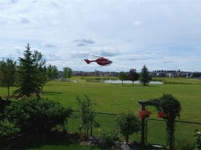 First responders work at the scene of a call involving a two-year-old girl found in a man-made lake in Morinville on Saturday, July 25, 2015. The girl was pronounced dead.