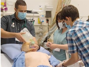 (From left) Yves Landry, Sarah Bieganek and Pierre Alexandre Menard take part in a simulation. Forty four critical-care trainees from across Canada are at the University of Alberta for a two-day training course that simulates a medical emergency, training them to be intensive-care doctors. They are participating in simulated medical scenarios in Edmonton. July 9, 2015.