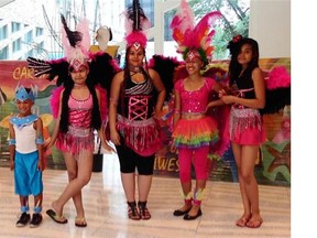 Grayson Bews, Emma Baine, Aisha Baine, Hayley Bews and Kayla Baine show off their vibrant costumes at City Hall on Wednesday in preparation for the Cariwest Festival.