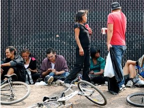 Homeless people try to stay cool across the street from the Boyle Street Co-Op on July 11, 2015.