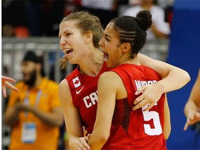 Katherine Plouffe, left, and point guard Kia Nurse celebrate Canada’s gold-medal win against the United States in women’s basketball at the Pan Am Games on Monday at Toronto.