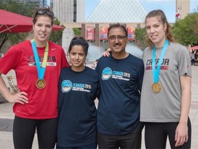 Katherine (wearing red) and Michelle Plouffe (wearing grey) from Canada’s senior women’s basketball team show off their Pan Am gold medals while posing with Coun. Amarjeet Sohi and his daughter Navseerat Sohi on Wednesday during an event at Churchill Square to promote the upcoming FIBA Americas Women’s Basketball Championship.