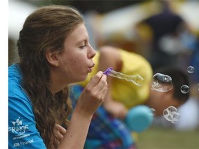 Kelly Heinemann blows bubbles after the opening ceremony for the Kids Fringe in Edmonton on Friday Aug. 14, 2105.