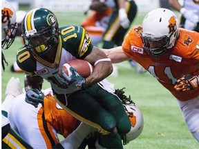 B.C. Lions Alex Hoffman-Ellis tackles Edmonton Eskimos Chad Simpson during the fourth quarter of CFL football action in Vancouver on Thursday. The Eskimos lost 23-26, prompting many fans to question by Edmonton didn’t attempt a 48-yard field goal in the final minutes of the game.