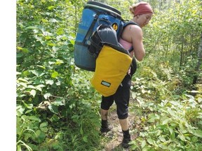Magali Moffatt hauls gear during the grueling Grand Portage in northeastern Minnesota, during their cross-country canoe trip between Edmonton and Montreal.