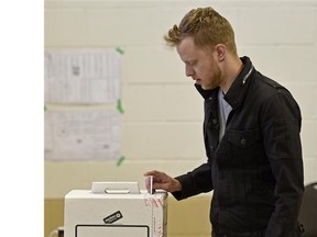 Brendan Taylor puts his ballot in the box during the 2015 Alberta provincial election. The federal election is October 19, 2015.