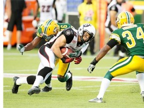 Ottawa Redblacks’ Greg Ellingson (82) is tackled by Edmonton Eskimos’ John Ojo (26) and Ryan Hinds (34) during the game in Edmonton on July 9. Rookies and veterans alike on the Eskimos defensive line aim to make more big plays against the Saskatchewan Roughriders on Friday at Commonwealth Stadium.