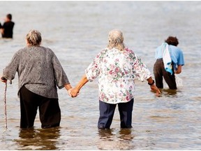 Pilgrims wade into Lac St. Anne in July 2012 despite an advisory to stay out of the lake because of blue-green algae. An advisory was issued for the lake, believed to have healing powers, on July 17, 2015.