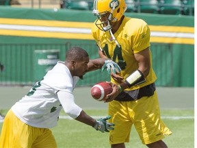 Quarterback James Franklin hands the ball off to running back Shakir Bell during the Edmonton Eskimos’ practice Monday at Commonwealth Stadium.