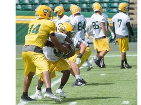 Quarterback James Franklin hands off to Shakir Bell at the Edmonton Eskimos practice as the Green and Gold prepare to host the Saskatchewan Roughriders on July 31 at Commonwealth Stadium in Edmonton, July 27, 2015.