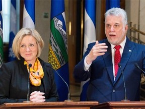 Quebec Premier Philippe Couillard, right, responds to reporters questions as Alberta Premier Rachel Notley looks on, Tuesday, July 14, 2015 at a joint news conference in Quebec City.