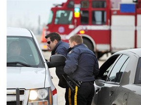 EPS and RCMP officers confer as they block off the area in an industrial park around Panther Industries on Dec. 9, 2012, after a hydrochloric acid spill.