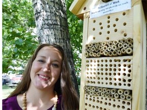 Rebecca Ellis poses with a “bee hotel” installed on a tree downtown in Edmonton on Monday, July 20, 2015.