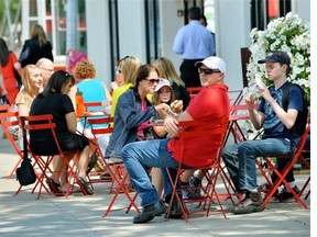 Restaurant patrons enjoy lunch on a sidewalk patio in downtown Edmonton. Albertans have not cut down on spending at restaurants and bars despite a weaker economy, figures show.
