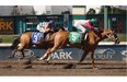 Rico Walcott, riding For Cash, wins the Fred Jones stakes race ahead of Killin Me Smalls ridden by Ruben Lara at Northlands Park racetrack on July 18, 2015 in Edmonton.