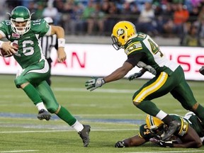Saskatchewan Roughriders’ Brett Smith (16) ­— dodging a tackle from Edmonton Eskimos’ Ryan Hinds (34) and Deon Lacey (40) during a pre-season game in Fort McMurray — will try to reverse his team’s fortunes Friday night at Commonwealth Stadium as the rookie quarterback faces the best defence in the league.