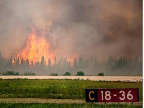 In this July 5, 2015 photo, flames rise from a wildfire near La Ronge, Sask. Canadian soldiers arrived July 7 to help battle raging wildfires, where about 13,000 people have been evacuated in recent days.