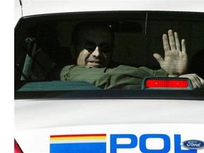 Thomas George Svekla gestures to photographers as he is taken away  from the Fort Saskatchwan courthouse after his first court appearance on May 11, 2006.