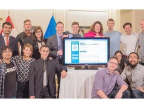 Three teams that won awards in the Apps for Alberta contest pose with Deron Bilous, Minister of Service Alberta (on left side of TV), in Edmonton on August 12, 2015.